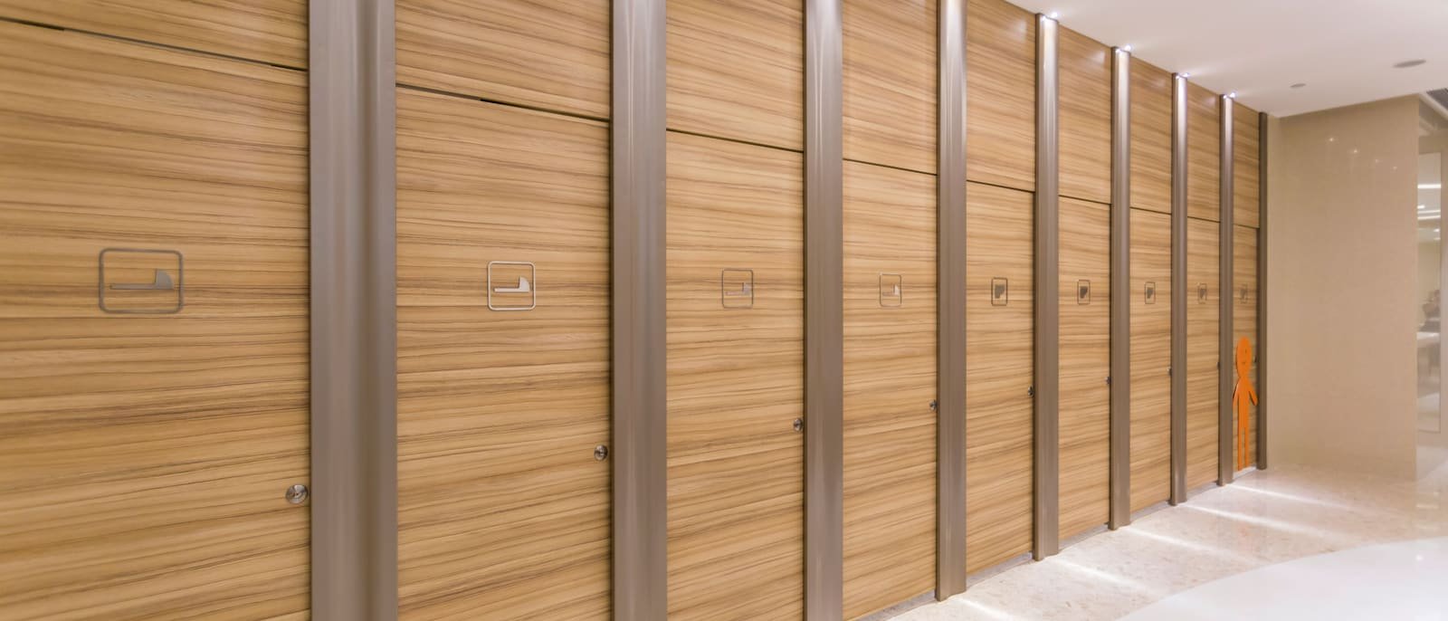 Pasillo con revestimiento vertical de paneles de madera y columnas metálicas