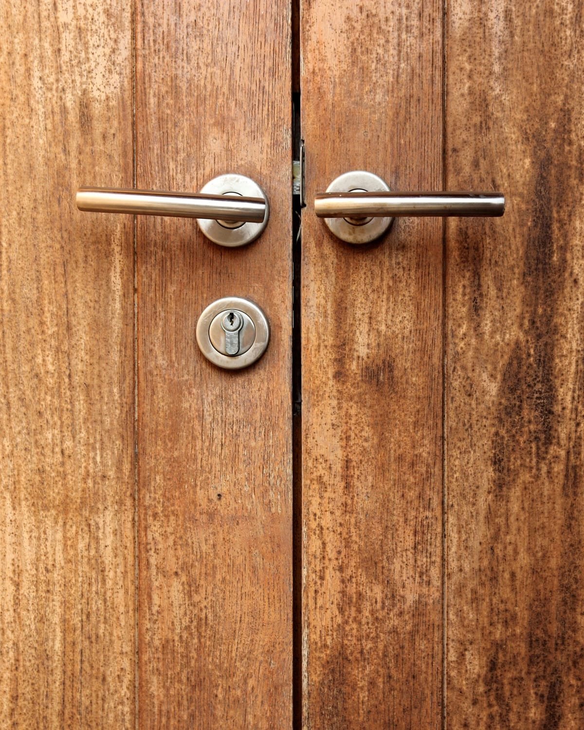 Detalle de doble puerta de madera con manijas metálicas